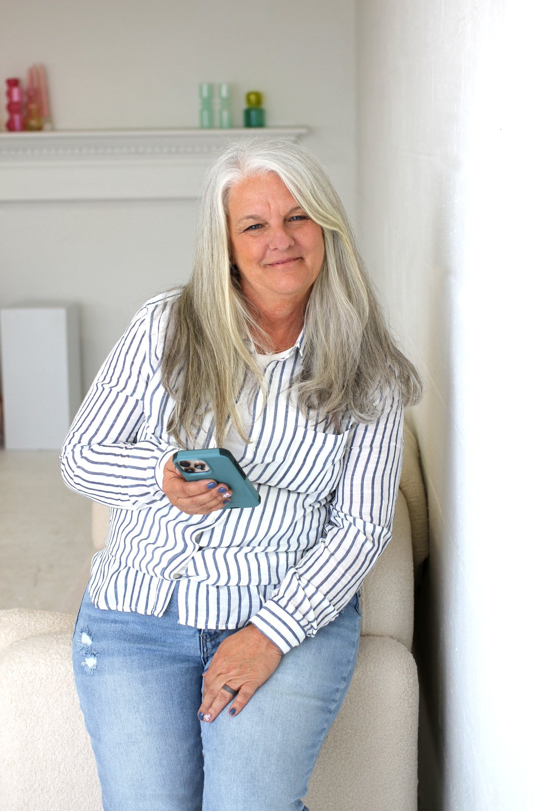 Linda Easterday of The Hive Coaching Co., smiling with her phone in hand